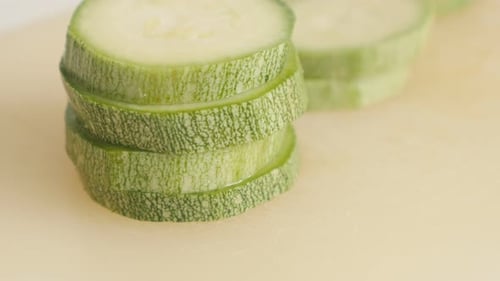 Sliced Pepo cylindrica on cutting board close-up 4K 2160p 30fps UltraHD tilting footage - Slices of