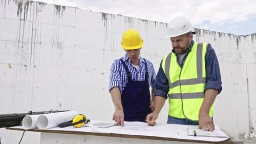 Ingenieure diskutieren am Tisch über Blueprint
