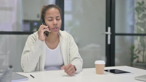 Woman Talking on Phone at Desk in Office
