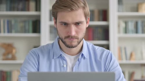 Young Adult Working on Laptop in Home Office