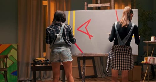 Talented Female Painters Collaborate to Create a Modern Painting Making Precise Brush Strokes