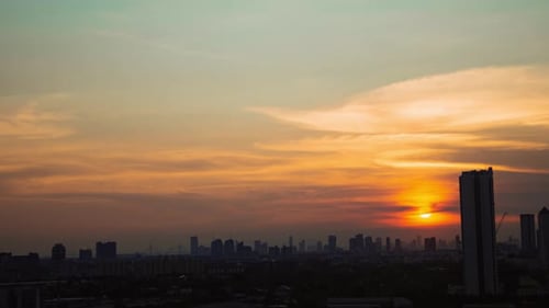 Sunset cloudy sky time lapse on downtown cityscape building in the evening