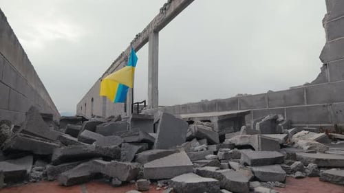 Wehende ukrainische Flagge auf dem von Russland im Krieg zerstörten Gebäude
