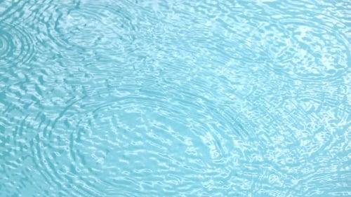 Raindrops Create Ripples in a Calm Water Pool