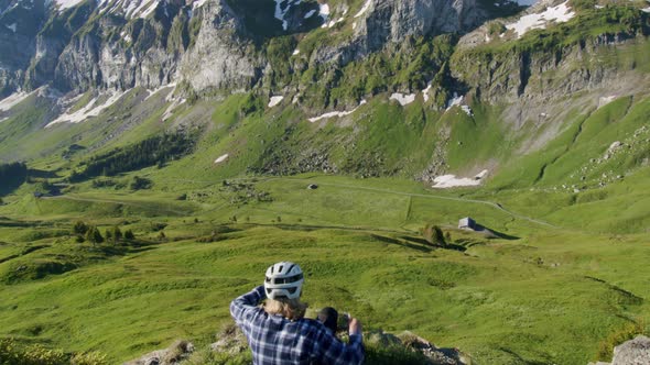 Mountain biker sits down and takes in the view from a ridge of abrupt ...