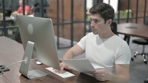 Paperwork By Creative Young Man at Office