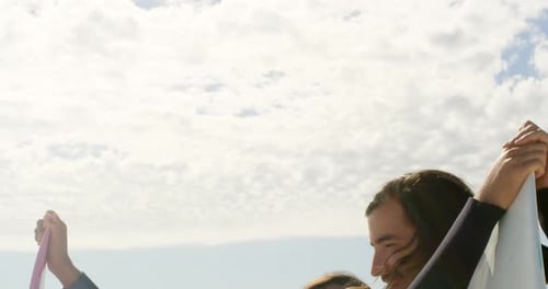 Couple standing with surfboard on the beach