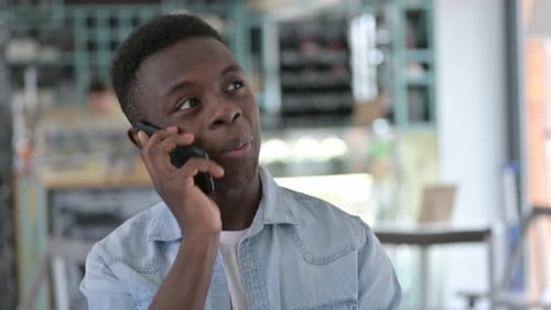 Young Adult Conversing on Cellphone Indoors