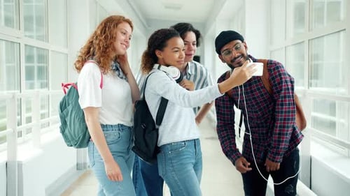 Group of Students Taking Selfie in University Hall Using Smartphone Posing