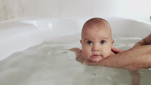 Cute Baby Enjoys Water During Bathtime