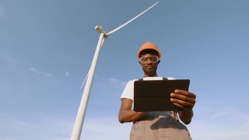 Afroamerikanischer Techniker nutzt digitales Tablet bei der Steuerung der Arbeit
