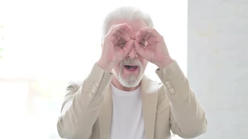 Joyful Senior Man Making Binocular Gestures and Dancing