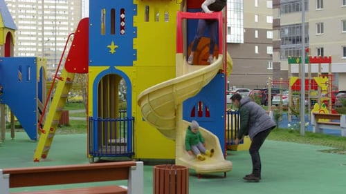 Kaukasische Eltern und Sohn haben Spaß auf Rutsche auf dem Spielplatz