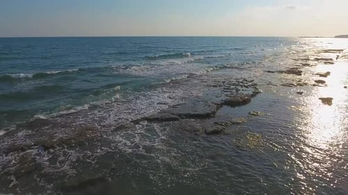 Flaches Felsenriff zwischen Meer und Strand