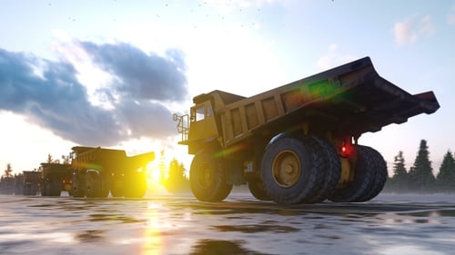 Giant Industrial Dump Trucks Driving in Convoy at Sunrise