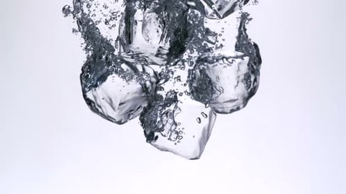 Ice Cubes Dropping Into Water Creating Bubbles