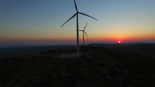 Flying over windmills at dusk