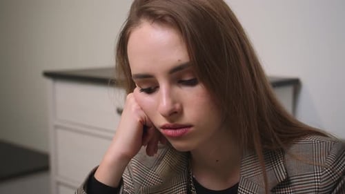 Young Woman Resting Head in Hand Indoors