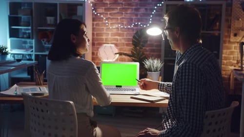 People Talking in Office Pointing at Laptop Chroma Key Green Screen at Night