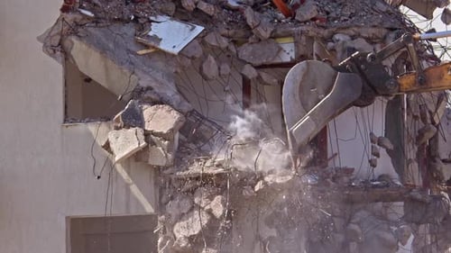 Excavator Demolishing Building with Water Spray