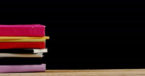 Stack of Colorful Books on Wooden Table