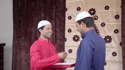 Muslim men giving sweet box on Eid