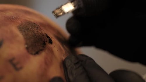 Tattoo Artist Applying Ink on Arm