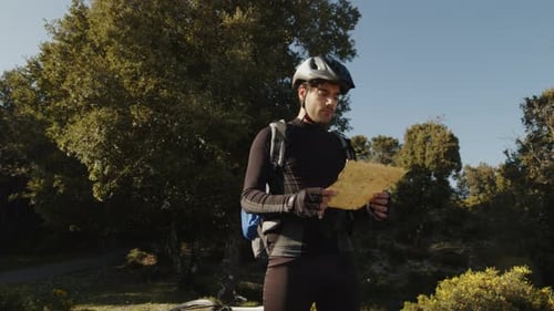 Cyclist Reading a Map in the Forest