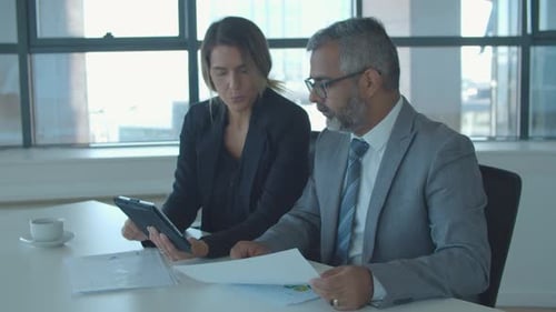 Business Colleagues Discussing Data at Bright Office Meeting