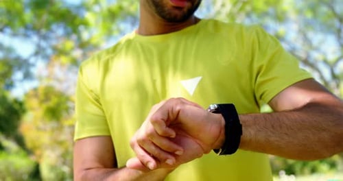 Man using smartwatch in park 4k