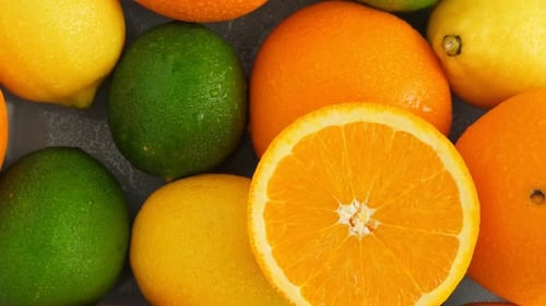 Half Cut Juicy Orange on Citrus Fruit Background, a Lot of Lemon, Oranges and Limes Top View