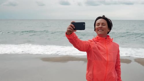 Woman Taking Selfie on Sandy Beach Near Ocean