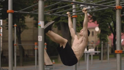 The Man is Doing Stomach Exercises in the Park