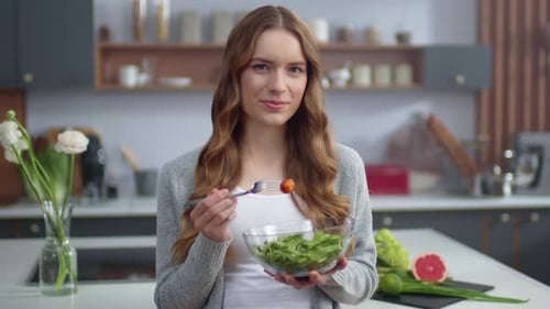 Woman Enjoys Healthy Salad in Modern Kitchen