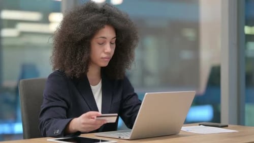 Erfolgreiches Online-Shopping auf dem Laptop von einer afrikanischen Geschäftsfrau