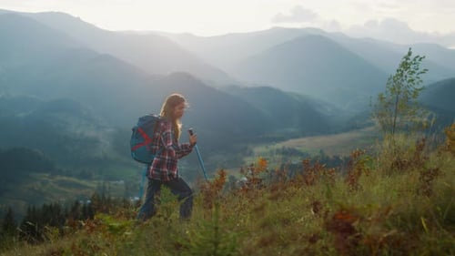 Woman Hiking in Mountains with Trekking Poles