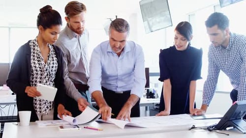 Team Reviews Blueprint in Bright Modern Office