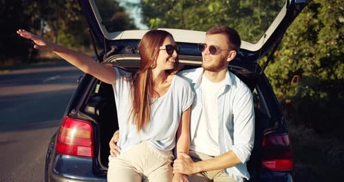 Young Couple Enjoying Roadside View by Car