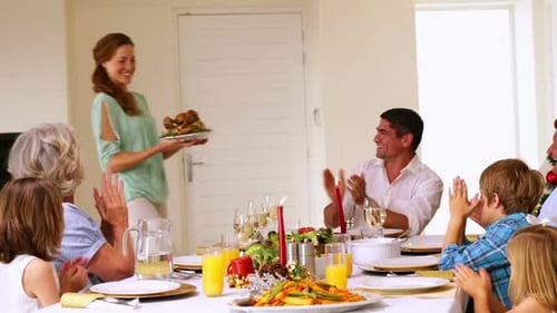Mother bringing turkey to dinner table at christmas
