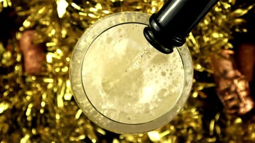 Pouring Champagne Into Glass with Festive Tinsel