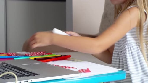 Child Glues Paper Art in Bright Room