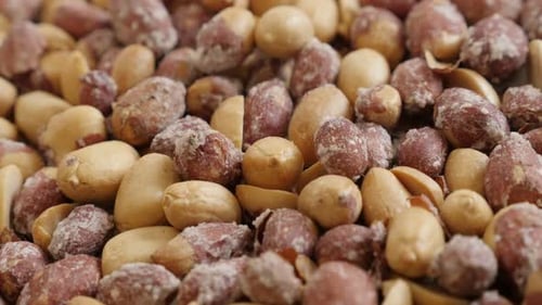 Langsame Neigung auf gerösteten Erdnüssen auf weißem Hintergrund 4K 2160p 30fps UltraHD-Aufnahmen - Gesalzener Snack Arach