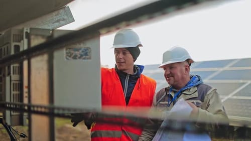 Engineers Inspect Solar Panel Array in Daytime