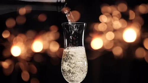 Champagne Pouring Into Glass With Bokeh Lights