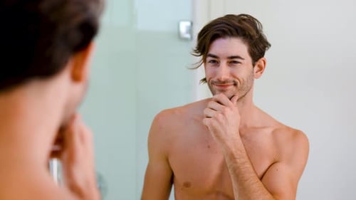 Man Admiring Himself in Bathroom Mirror