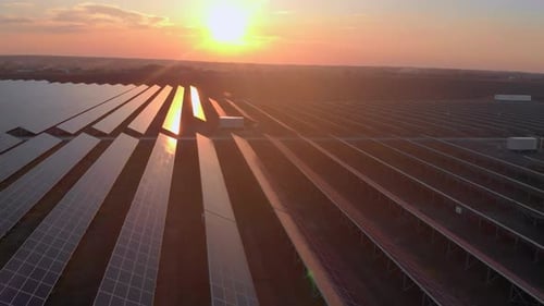 Aerial Drone View of Large Solar Panels at a Solar Farm at Bright Sunset in Early Winter