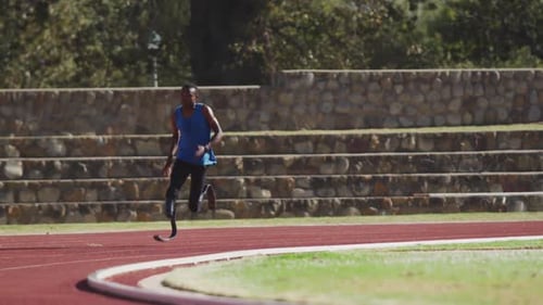 Athlete Runs on Outdoor Track on Sunny Day
