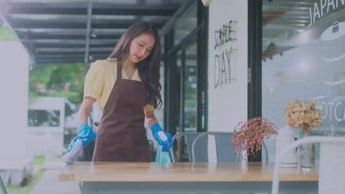 Close-up.Asian female worker clean the table is disinfected by sprinkling with an antiseptic spray