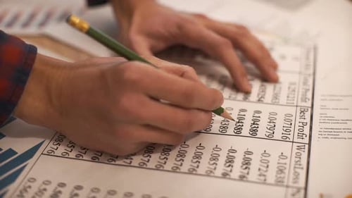 Hands Analyzing Charts and Data with Pencil