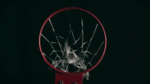 Basketball Swishes Through Hoop in Dark Environment